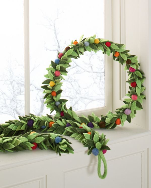 a wreath made out of felt sitting on top of a window sill next to a green ribbon