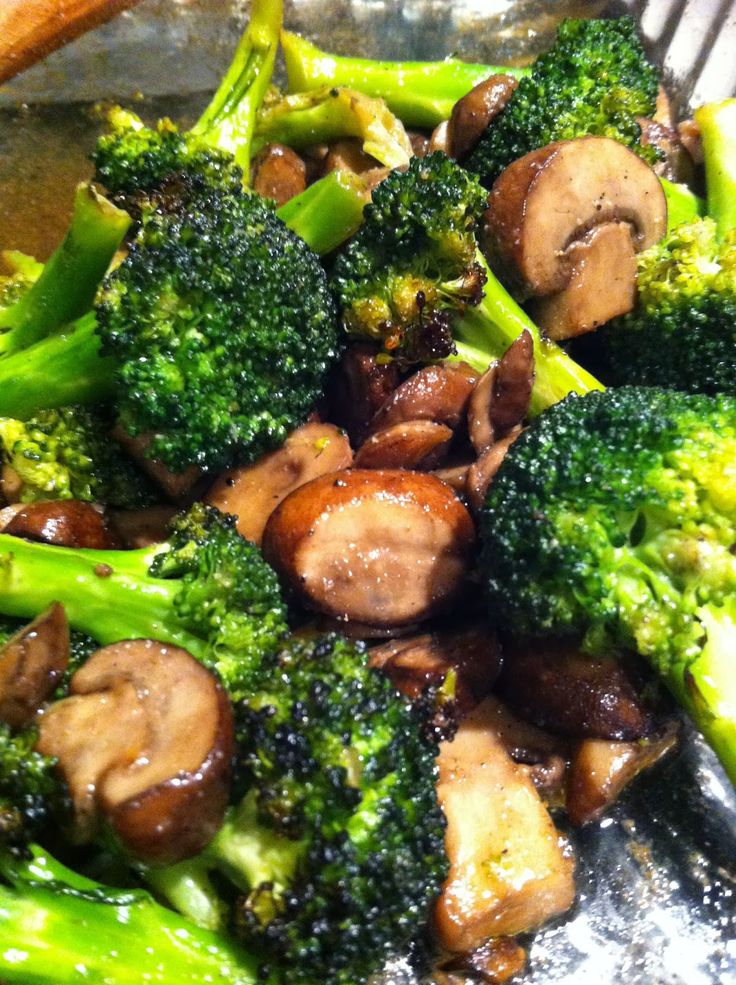 broccoli and mushrooms are being cooked in a pan