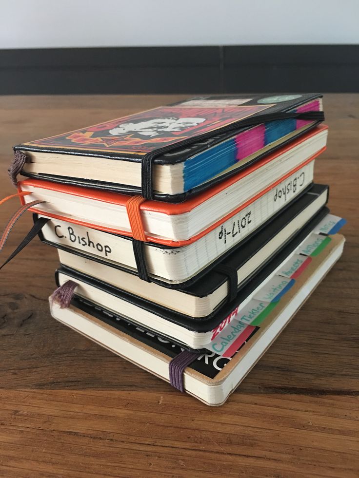 a stack of books sitting on top of a wooden table