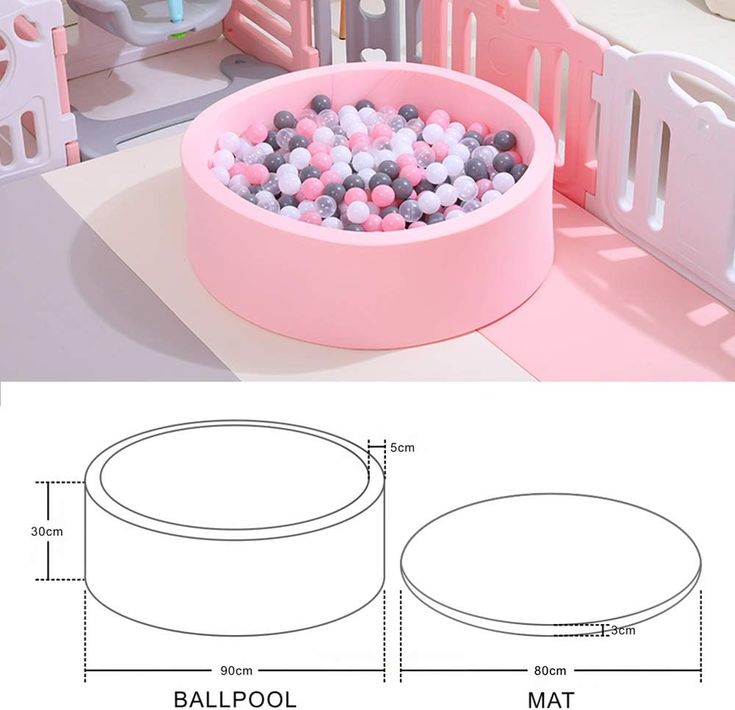 a pink bowl with balls in it sitting on top of a table next to a doll house