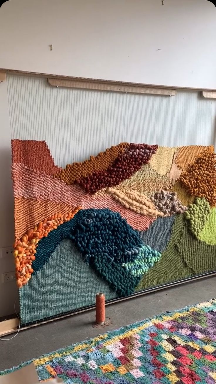 a multicolored rug is on the floor next to a wall