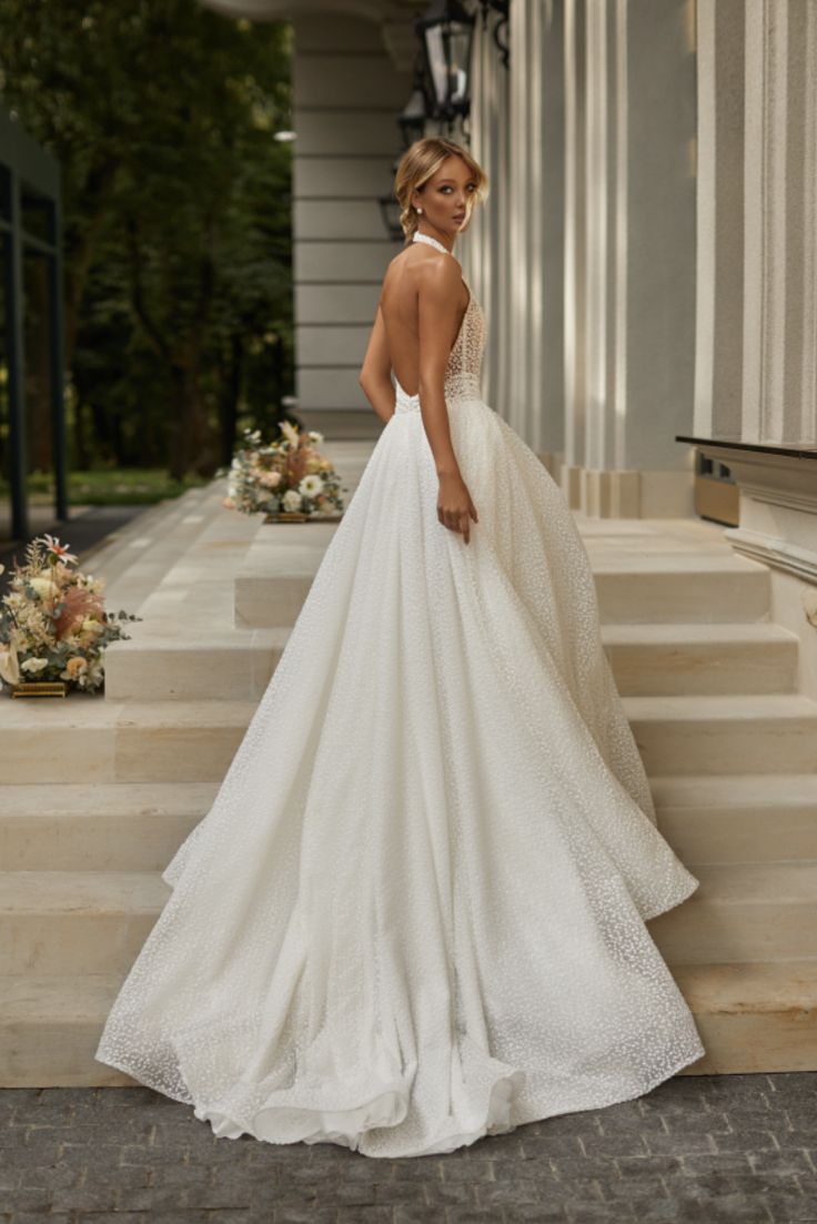 a woman in a wedding dress standing on some steps