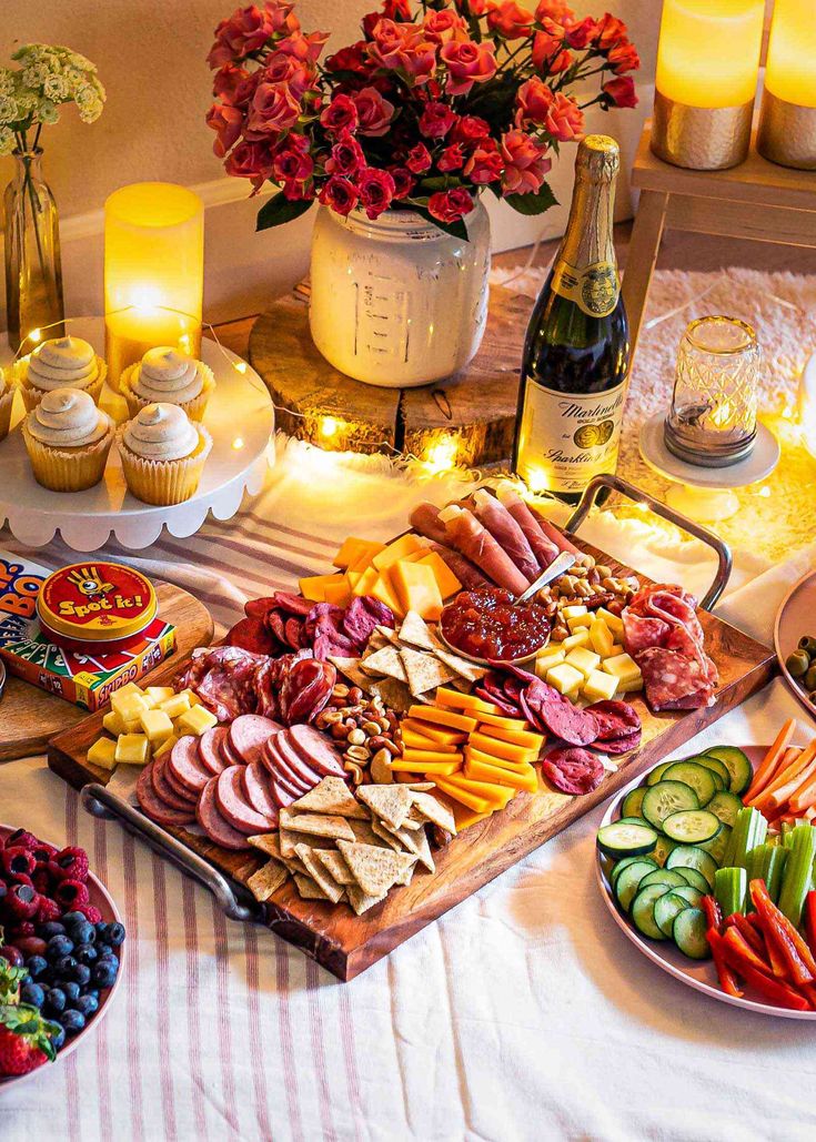 an assortment of food on a table with candles