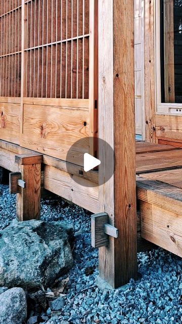 a wooden porch with rocks and gravel around it