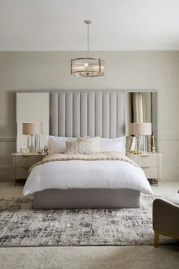 a large bed sitting in a bedroom on top of a white rug next to a chair