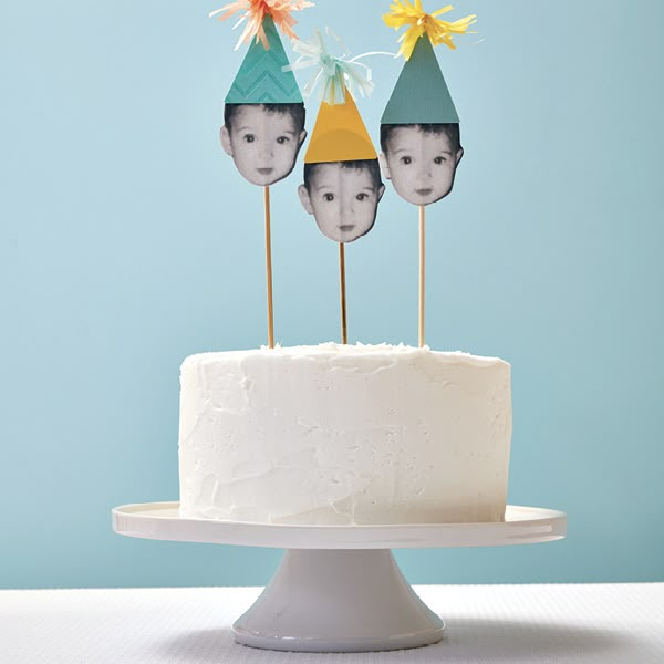 a cake topped with three little faces on top of it