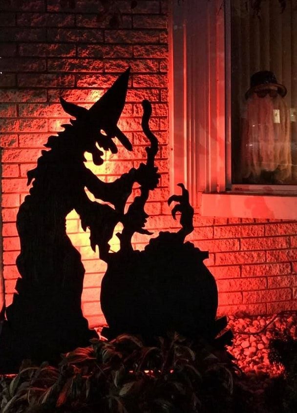 a dragon statue sitting in front of a brick building with red lights on it's windows