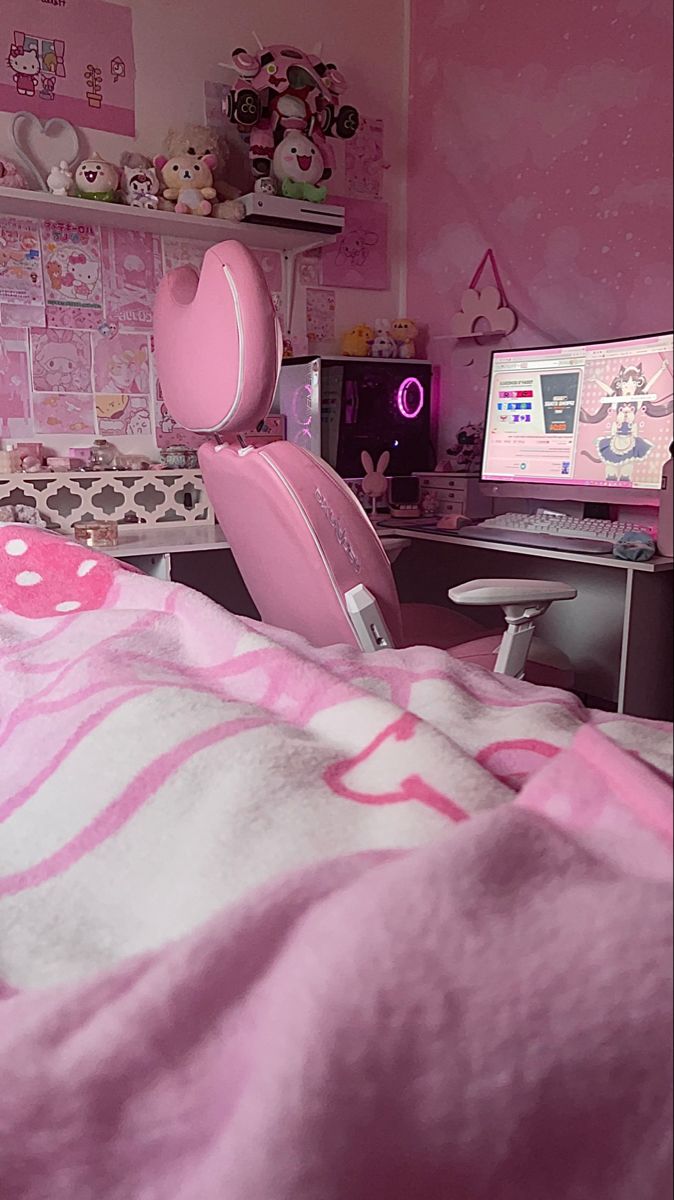 a bed with pink and white comforter next to a computer desk