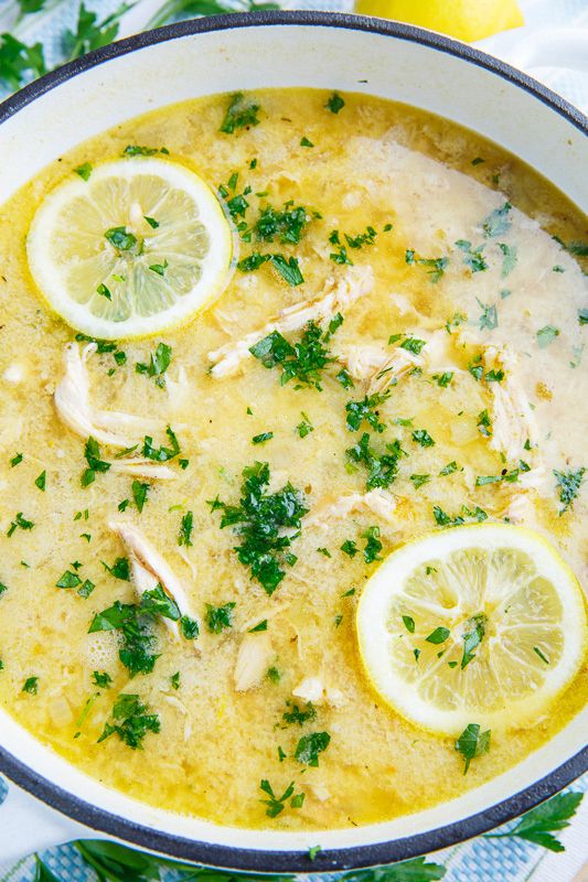 a bowl of soup with lemons and parsley