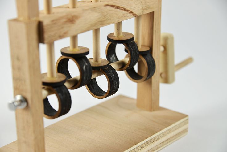 a wooden rack with several pairs of black and gold rings hanging from it's sides