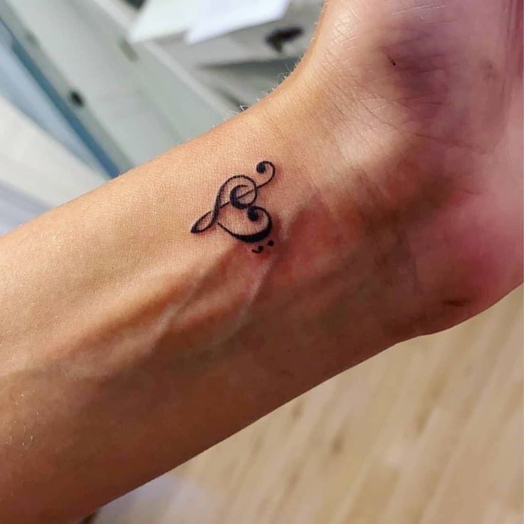 a small tattoo on the foot of a person with musical notes in their left ankle