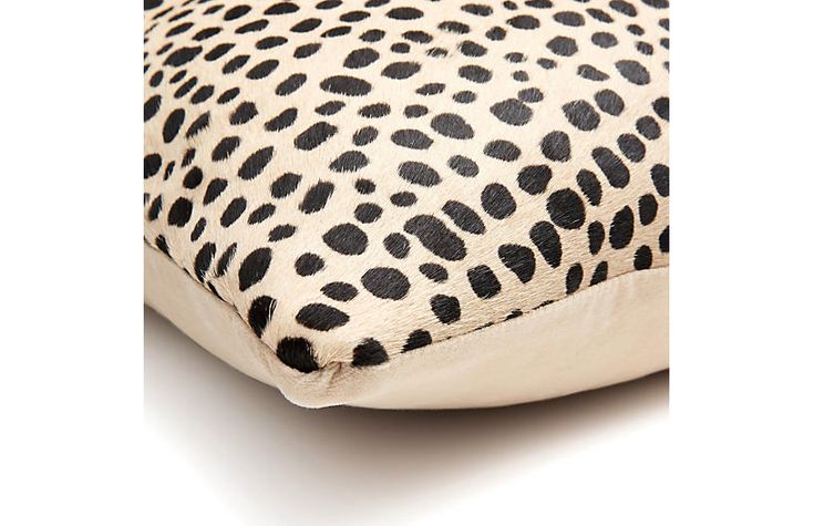 an animal print pillow with black spots on it's sides and the bottom half