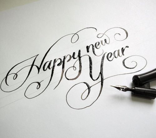 an ink pen writing happy new year on paper with the words'happy new year'written in cursive font