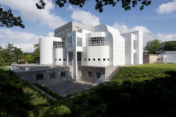 a large white building sitting on top of a lush green field