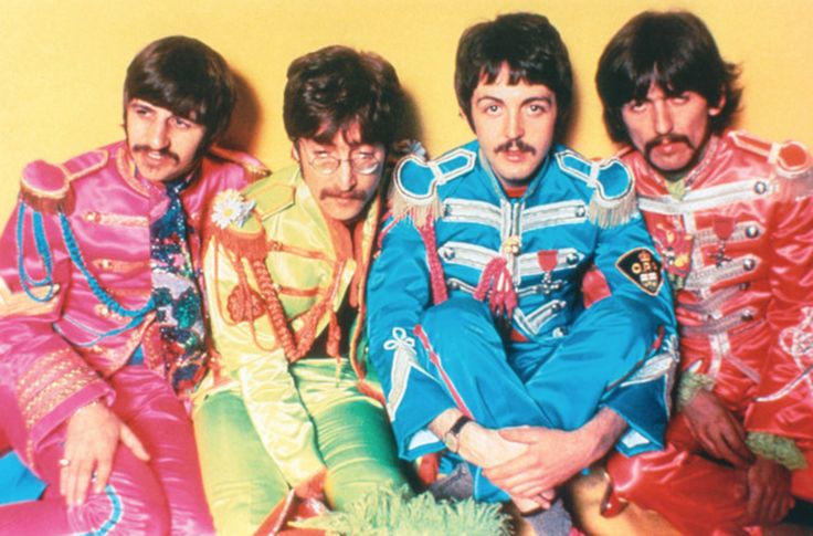 the beatles posing for a photo in their colorful outfits