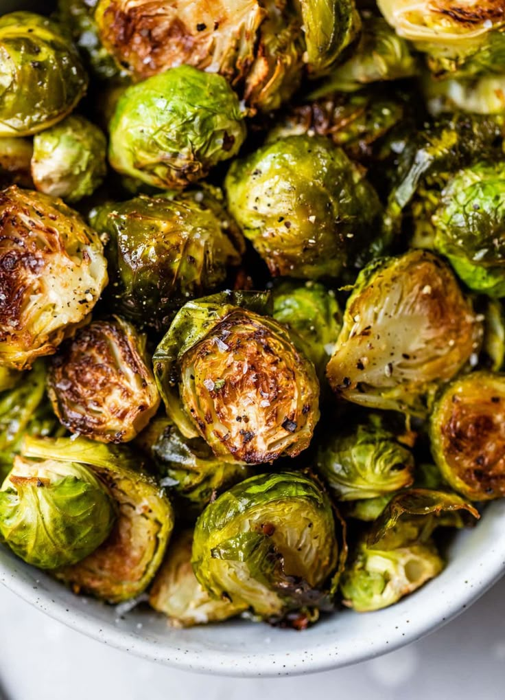 a white bowl filled with brussel sprouts on top of a table