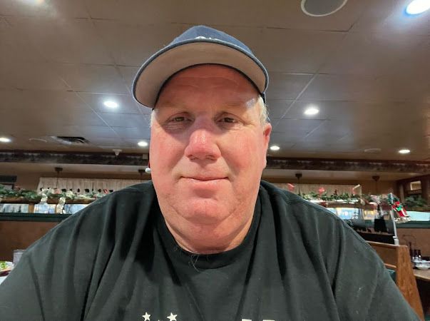 an older man wearing a baseball cap in a restaurant