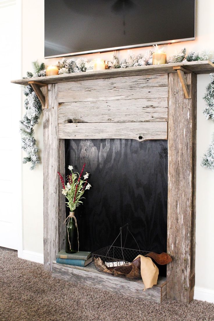 the fireplace is decorated with candles and greenery