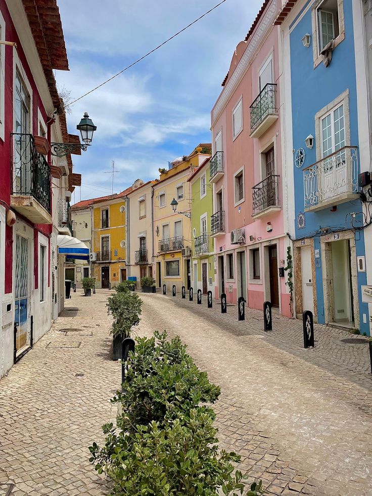 a cobblestone street lined with colorful buildings