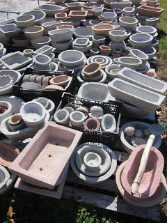 many pots and pans are stacked on top of each other in an outdoor area