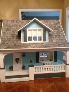 a doll house is shown in the middle of a room with hardwood floors and windows