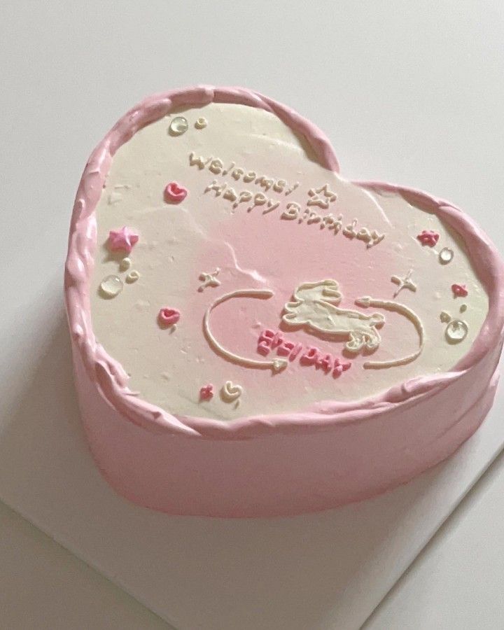 a pink heart shaped cake on top of a white table