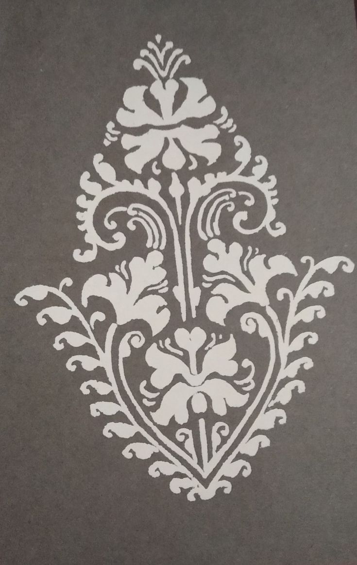 an intricately designed piece of paper with white ink on grey paper, in the shape of a flower