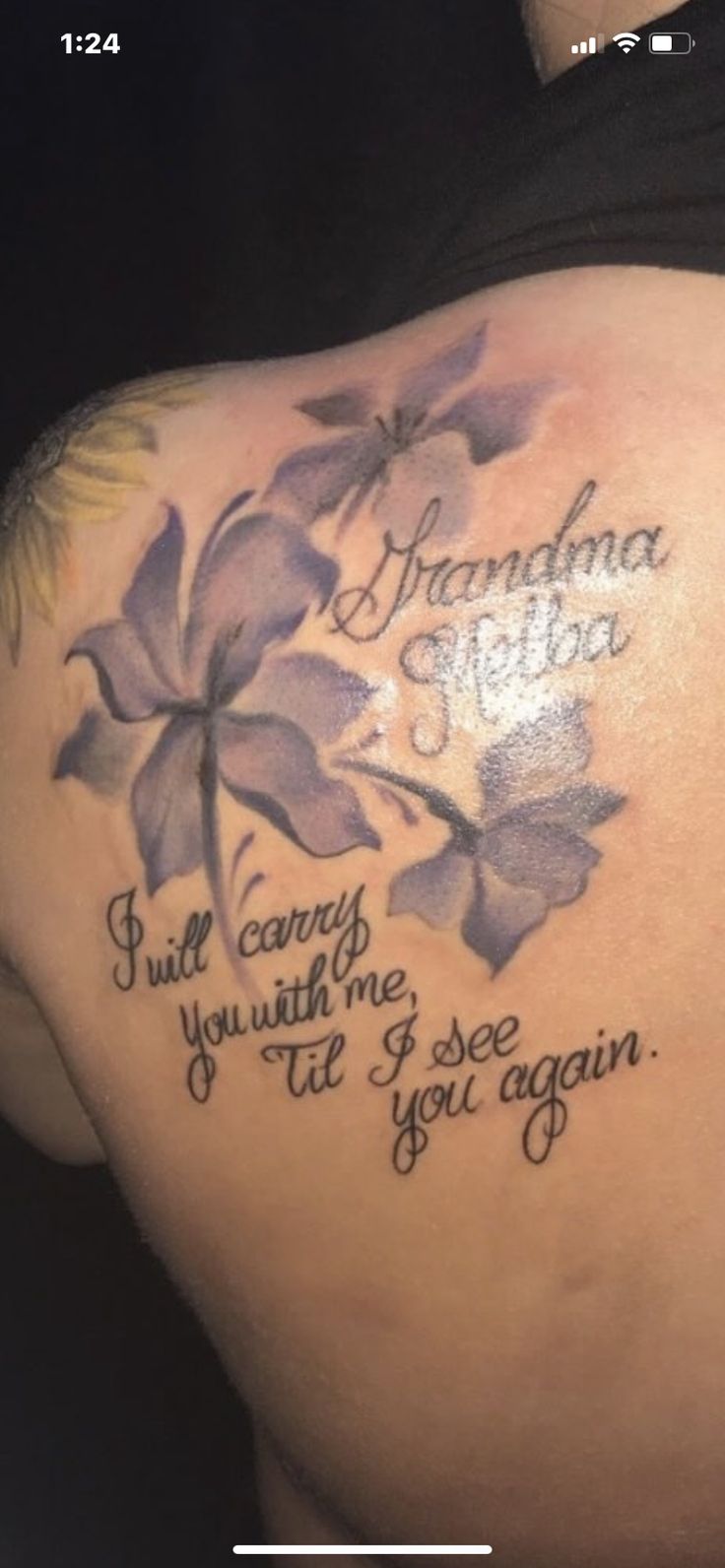 the back of a woman's shoulder with flowers and words written in cursive writing