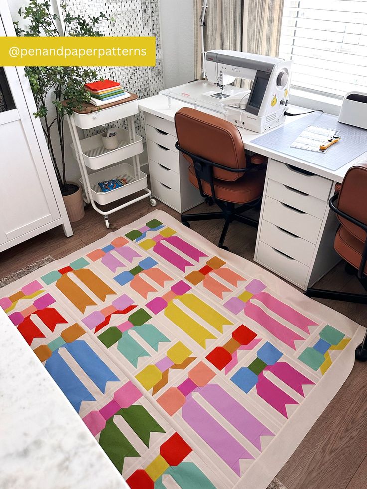 an area rug that has been made into a colorful pattern on the floor in front of a desk and chair