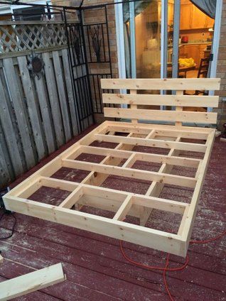 a wooden bed frame sitting on top of a deck