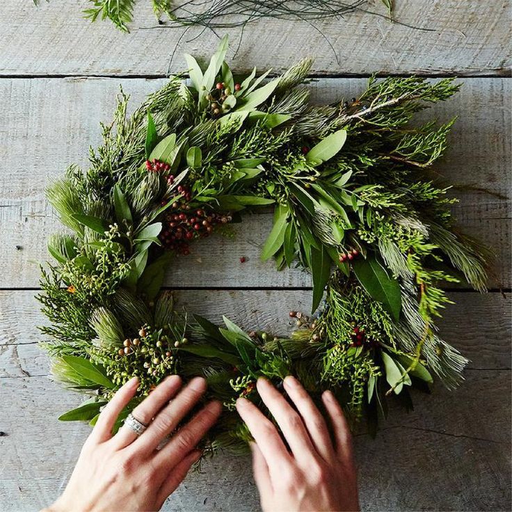 someone is making a wreath out of greenery