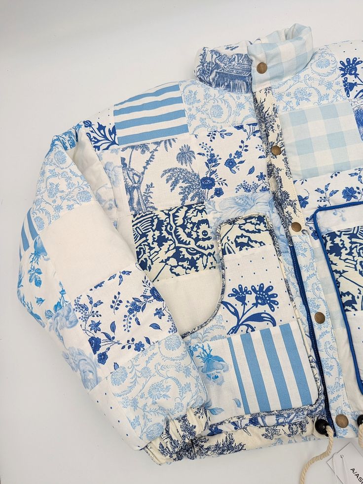 a blue and white patterned shirt laying on top of a table next to a tag