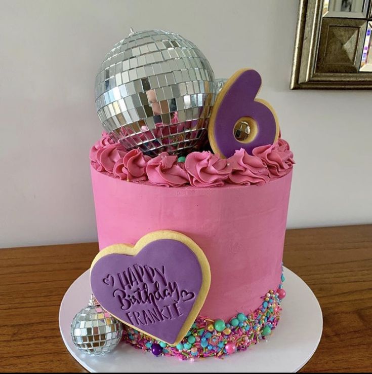 a birthday cake with pink frosting and decorations