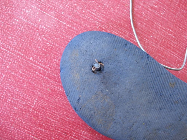 a blue piece of metal sitting on top of a red cloth covered floor next to a white cord