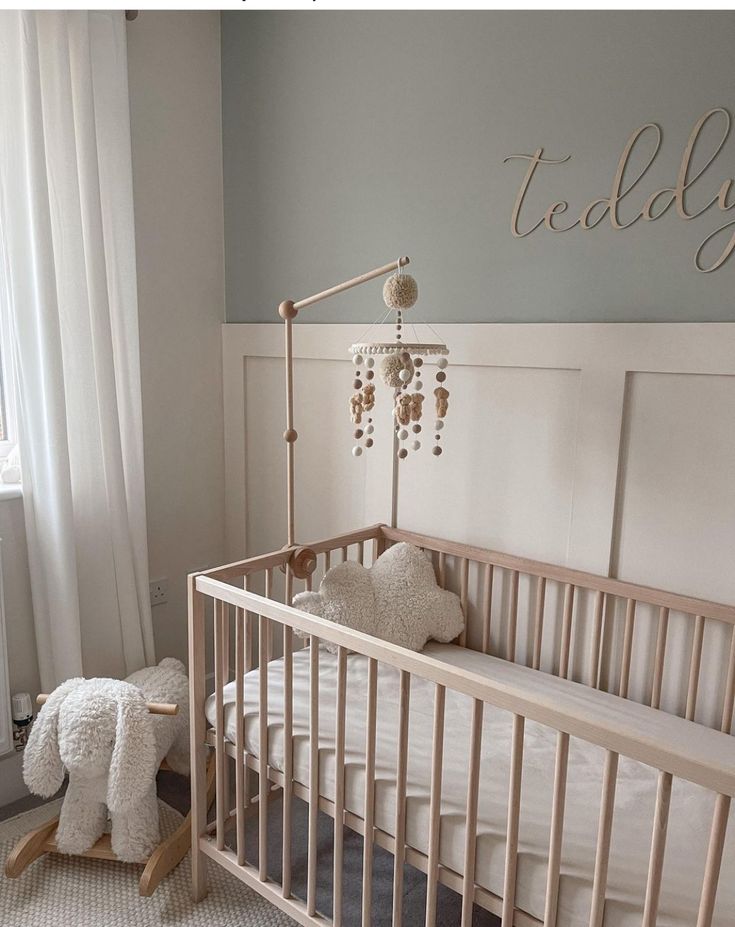 a baby's room with a crib and teddy bear