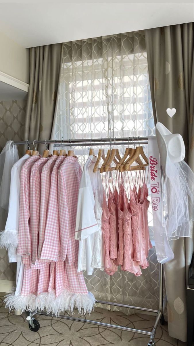 some clothes are hanging on a rack in front of a window