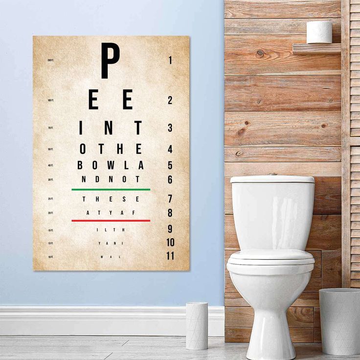 an eye chart on the wall next to a toilet