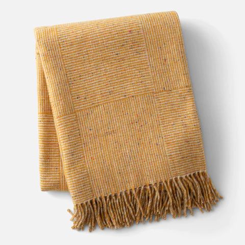 a yellow and brown blanket with fringes on it's end, against a white background