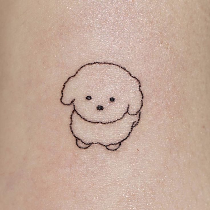 a small black and white dog tattoo on the stomach