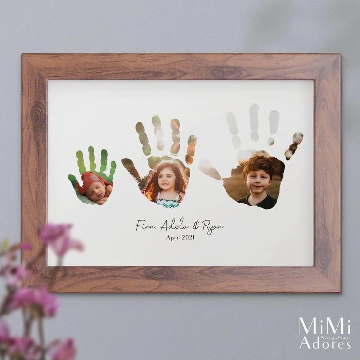 the family handprints are displayed in a wooden frame