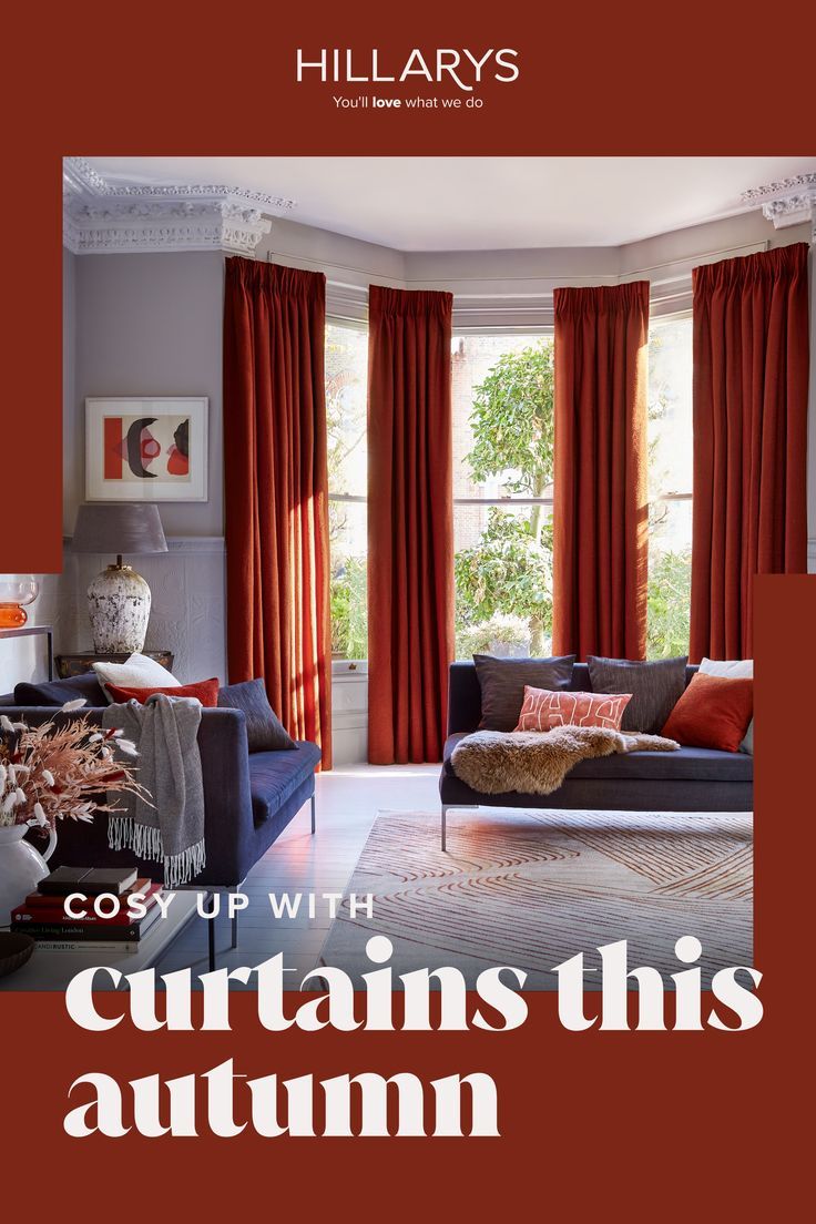 Warm burnt orange curtains in a large living room bay window. There are dark navy blue sofa's with red cushions, faux-fur throws and the room is light and spacious. Neutral Curtains, Brown Curtains, The Curtains, Red And Orange, Muted Tones, Spacious Living Room, Winter Night, Spacious Living, Roman Blinds