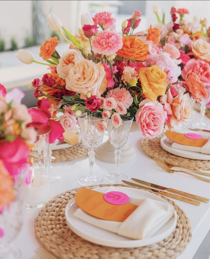 the table is set with flowers and place settings