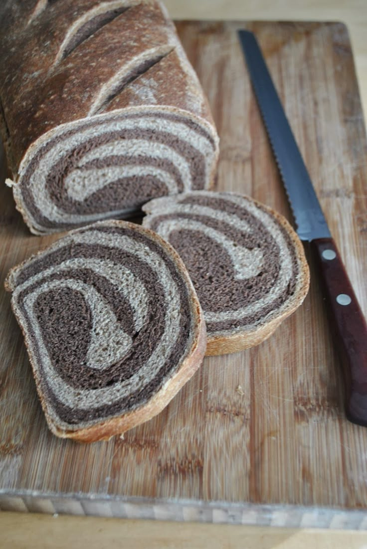 sliced loaf of bread sitting on top of a cutting board next to a knife