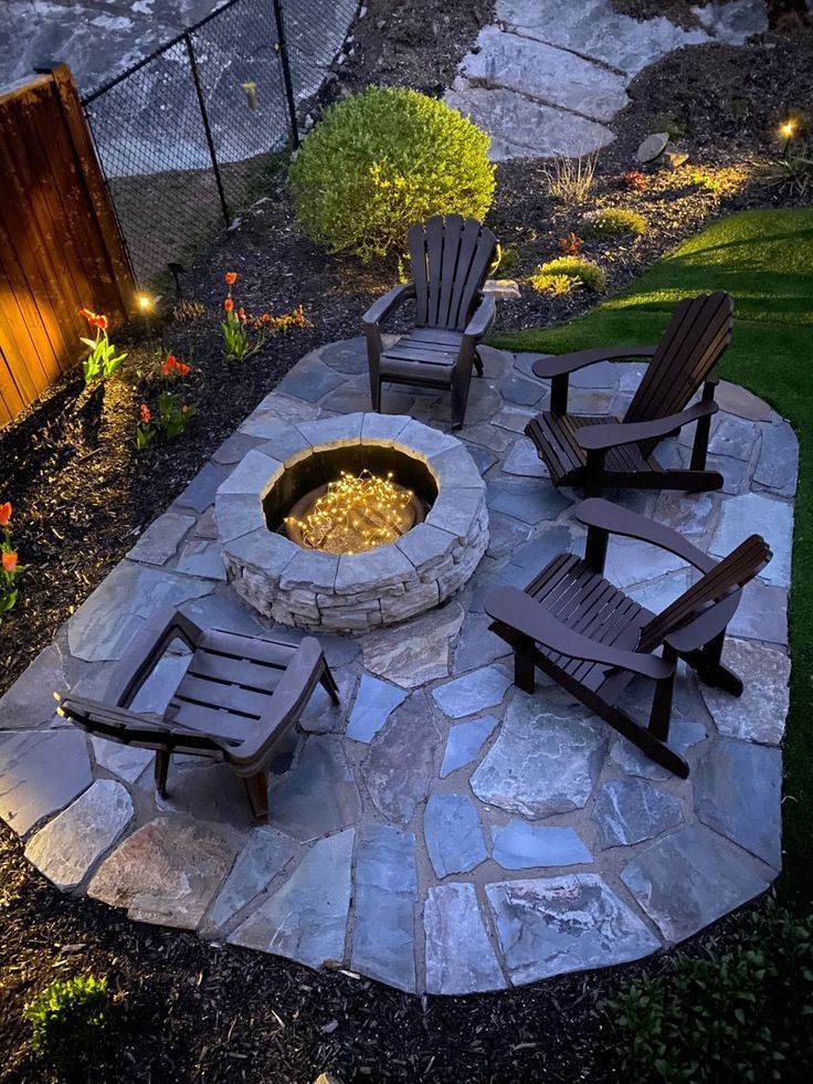 an outdoor fire pit with chairs around it