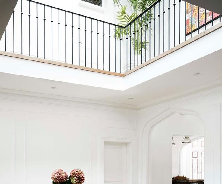 two vases with flowers sit on a table in the middle of a living room