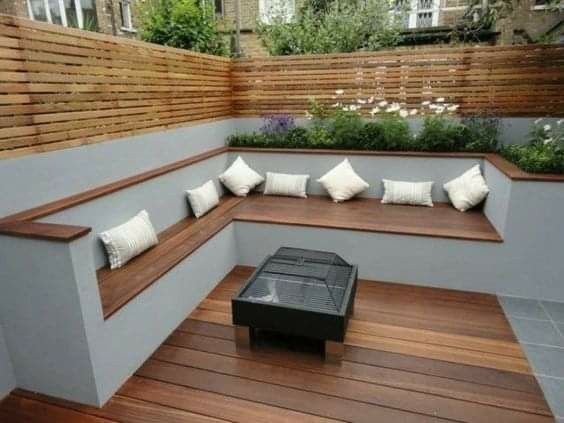 a wooden bench sitting on top of a hard wood floor next to a planter