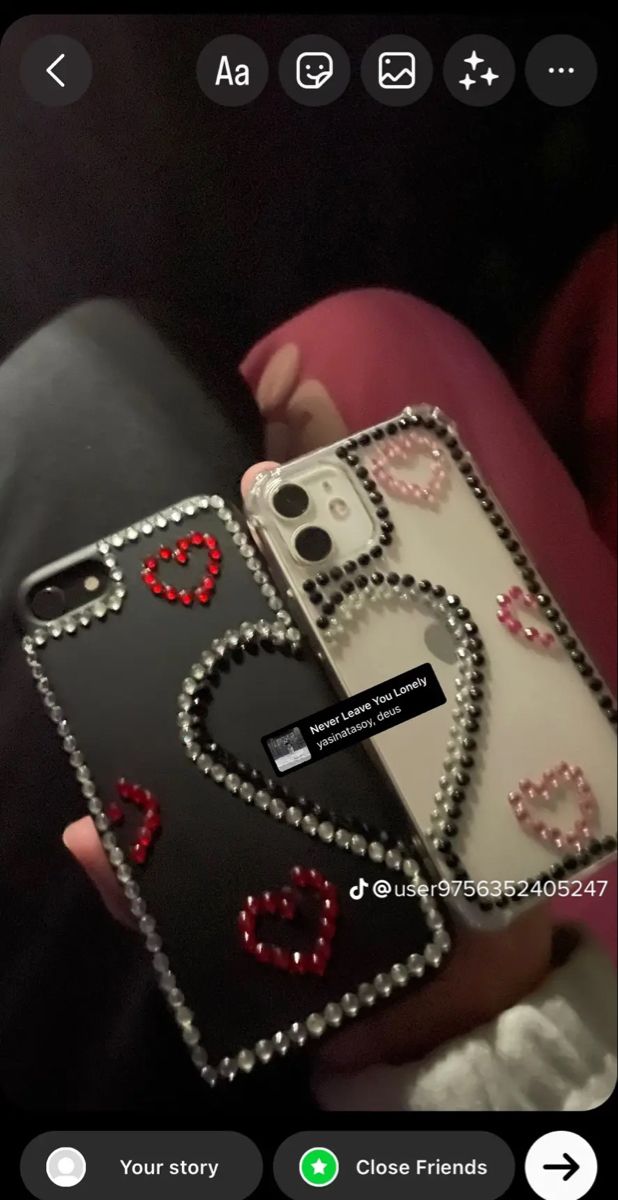 someone is holding up their phone case with hearts and chains attached to the back of it