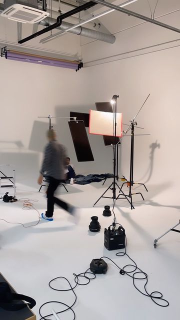 a man is running through a studio with lights and lighting equipment on the floor in front of him