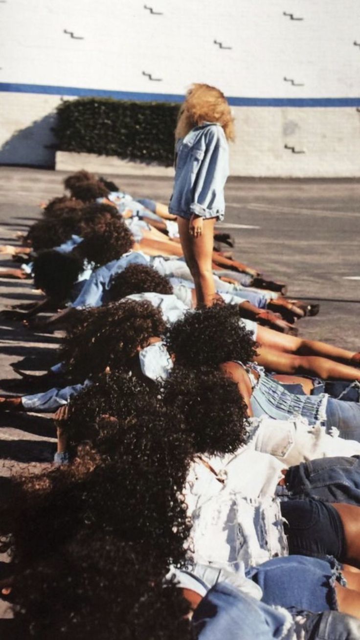 a group of women laying on the ground with their legs in the air and one woman standing