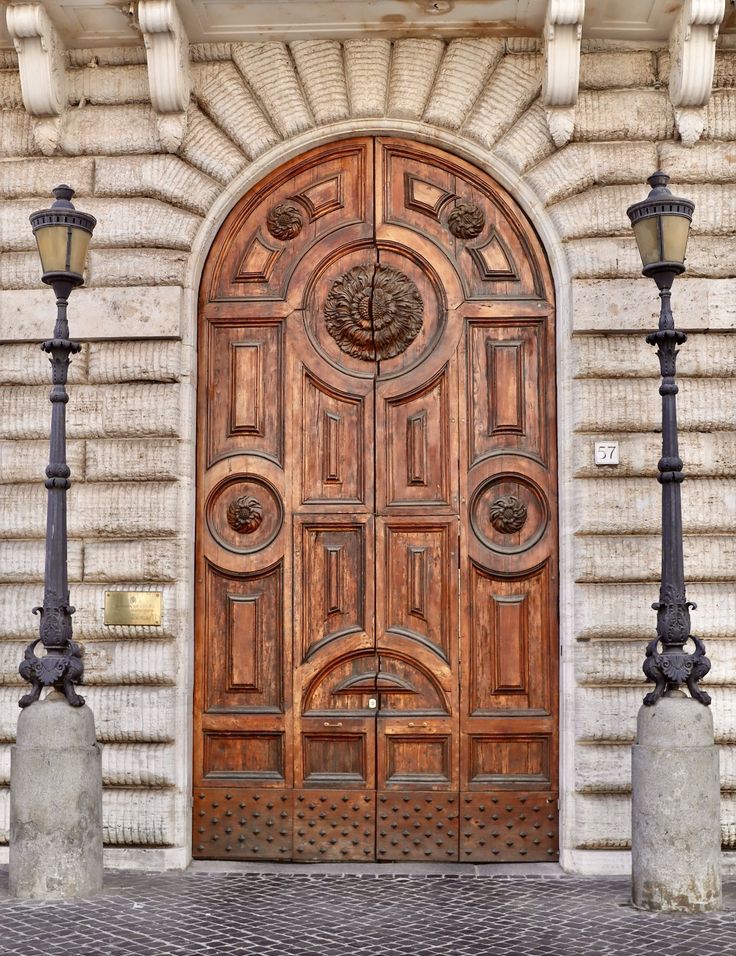 an old wooden door with two lamps on either side